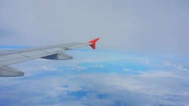 Uçakların kanatları ve gökyüzü manzarası bulutların üzerindeki pencereden