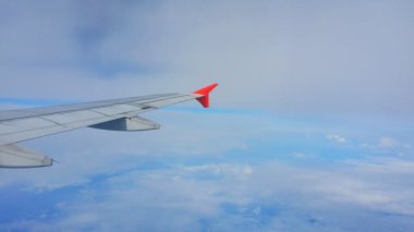 Uçakların kanatları ve gökyüzü manzarası bulutların üzerindeki pencereden