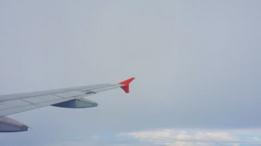 Uçakların kanatları ve gökyüzü manzarası bulutların üzerindeki pencereden