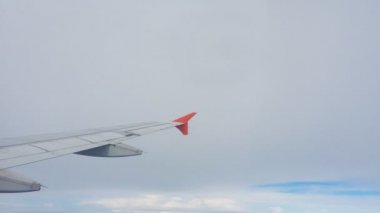 Uçakların kanatları ve gökyüzü manzarası bulutların üzerindeki pencereden