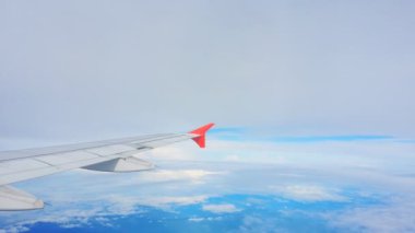 Uçakların kanatları ve gökyüzü manzarası bulutların üzerindeki pencereden