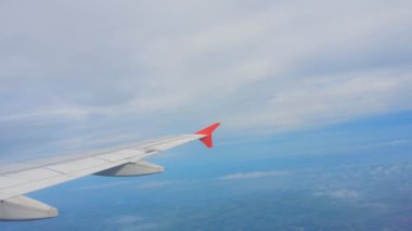 Uçakların kanatları ve gökyüzü manzarası bulutların üzerindeki pencereden