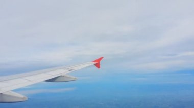 Uçakların kanatları ve gökyüzü manzarası bulutların üzerindeki pencereden