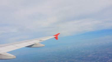 Uçakların kanatları ve gökyüzü manzarası bulutların üzerindeki pencereden