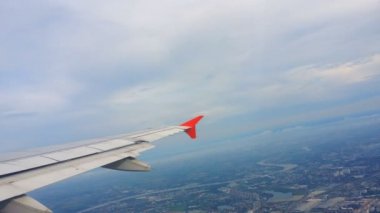 Uçakların kanatları ve gökyüzü manzarası bulutların üzerindeki pencereden