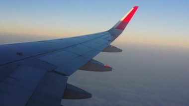 Uçakların kanatları ve gökyüzü manzarası bulutların üzerindeki pencereden