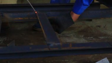 Kıvılcım saçan bir fabrikada kaynak yapan bir işçi.