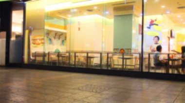 Bangkok, Tayland 'daki fast food restoranında oturan insanlar. Kamera optik yansıması.