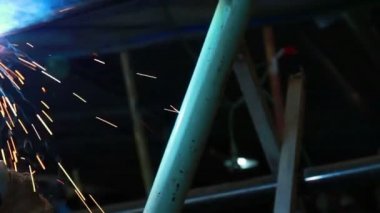 Kıvılcım saçan bir fabrikada kaynak yapan bir işçi.
