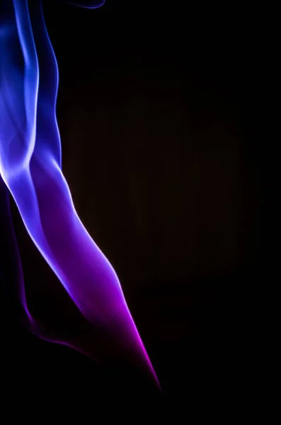 Duman karanlık bir arka plan üzerinde renkli damlama