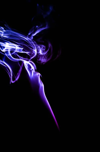 Duman karanlık bir arka plan üzerinde renkli damlama