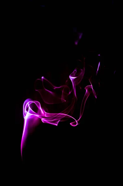 Duman karanlık bir arka plan üzerinde renkli damlama