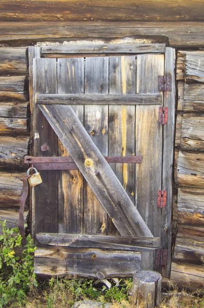 Terk edilmiş ahşap bir evde kapı kilidi ile eski ahşap kapı