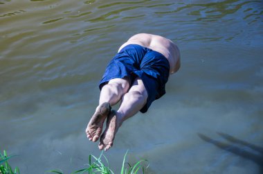 Büyük Şişman adam nehir kıyısından suya atlama