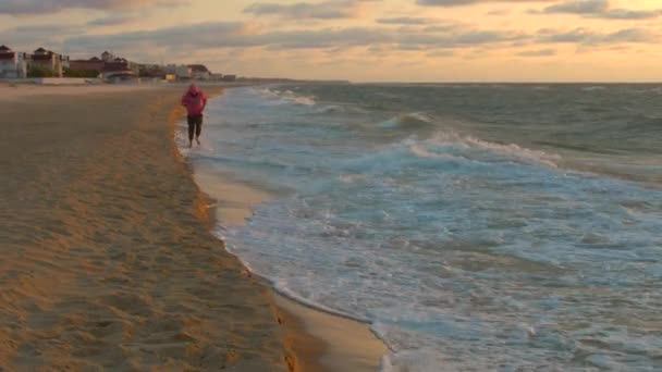 Le gars court le long de la mer au lever du soleil — Video