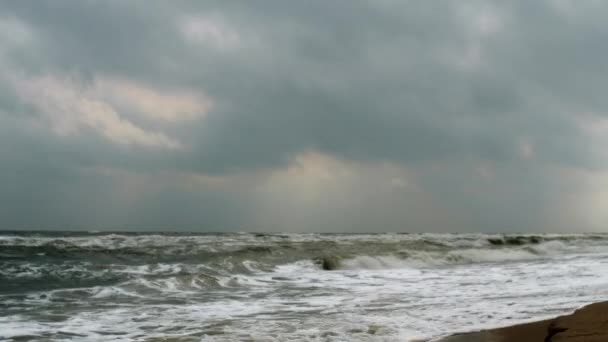 Raios de sóis rompendo as nuvens no mar em fúria — Vídeo de Stock