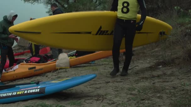 Adam diğer insanların arka plan karşı kano taşır kayıklar kontrol — Stok video