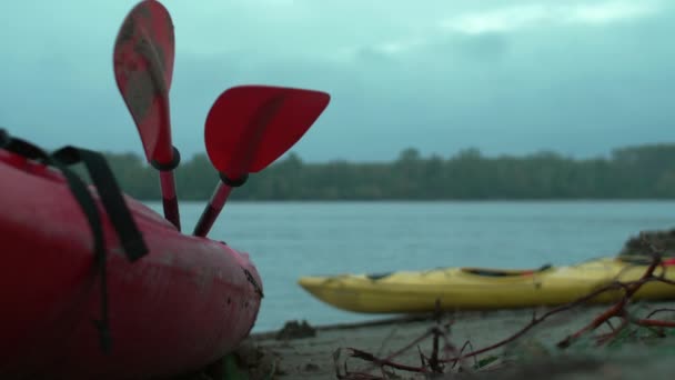 Peddels liggend in een kano op de oever van de rivier — Stockvideo