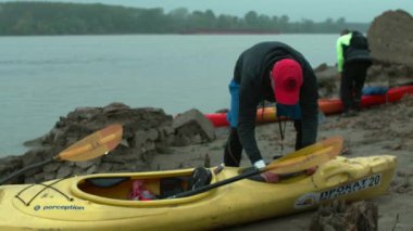 Bir insan bir kanodaki özel bölmeye bir şeyler koyar.