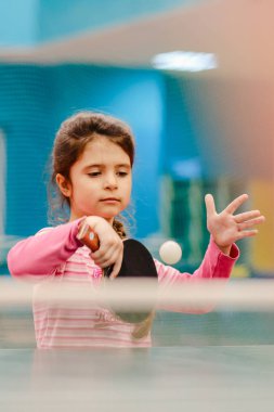 Tenis salonu, tenis raketi topu topu pitch isabet masa tenisi oynarken küçük ciddi kız