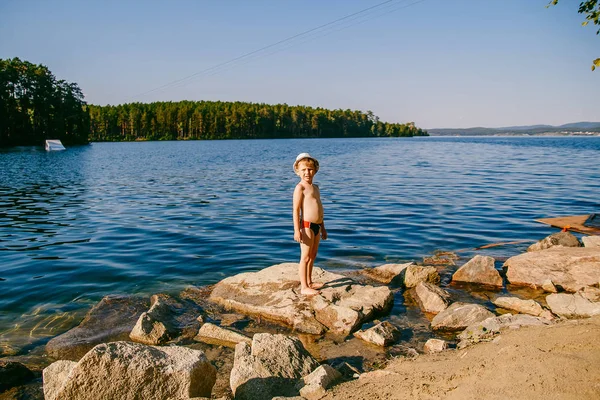 Söt Pojke Fem Badbyxor Och Hatt Står Stor Sten Stranden — Stockfoto