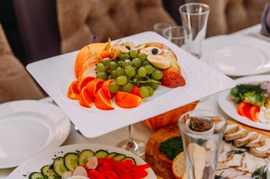 Restoran, üzüm, elma, muz, mandalina tabloda alınarak meyve tabağı