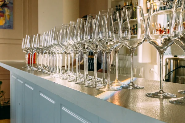 large transparent glass wine glasses stand on the bar counter