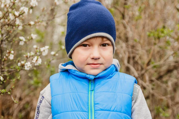 Симпатичный Мальчик Пяти Лет Синей Шапке Весной Саду — стоковое фото