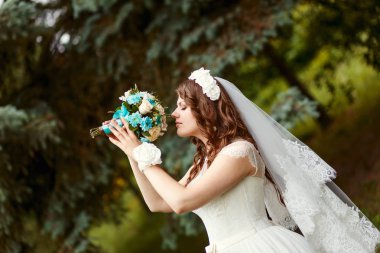 kıvırcık saç ve güzel bir buket onun elinde tutan peçe ile güzel mutlu gelin