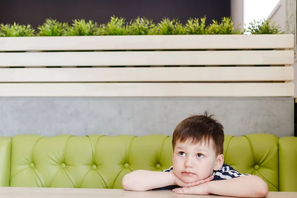 Четырехлетний Милый Заботливый Мальчик Сидящий Зеленом Диване Столом — стоковое фото