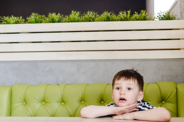 Niño Lindo Cuatro Años Sentado Sofá Verde Mesa —  Fotos de Stock
