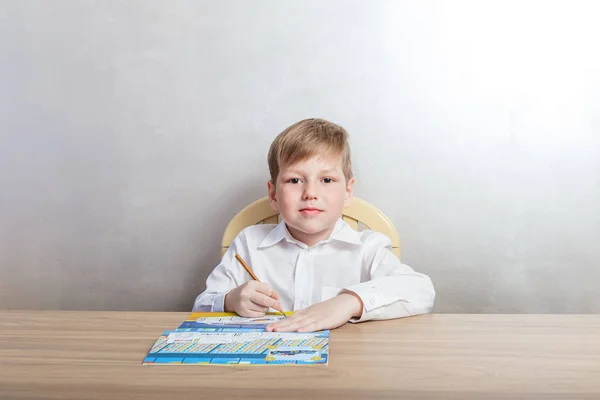 Çocuk Masa Başında Oturan Bir Beyaz Gömlek Beyaz Bir Arka — Stok fotoğraf