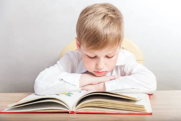 Bambino Camicia Bianca Seduto Con Libro Alla Scrivania Sfondo Bianco — Foto Stock