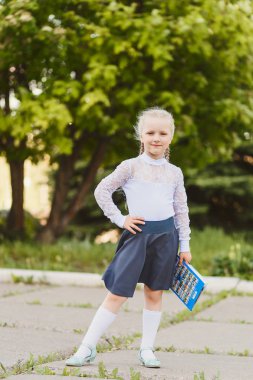 güzel küçük kız yedi yaşında bir okul üniforması havada pigtails ile