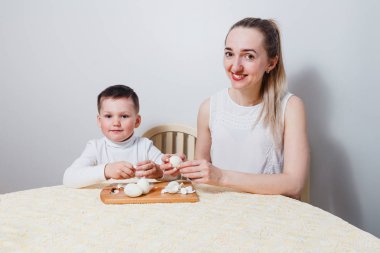 Anne ve çocuk temiz haşlanmış yumurta beyaz arka plan aynı masada