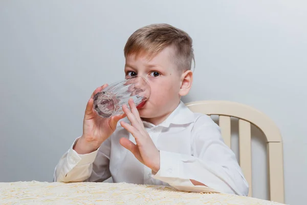 Chlapec Pije Vodu Sklenici Bílém Pozadí — Stock fotografie