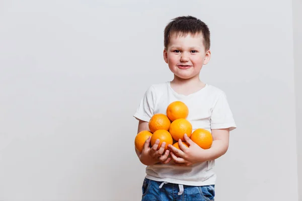 Šťastný Chlapec Bílé Tričko Pomeranči Rukou Bílém Pozadí — Stock fotografie
