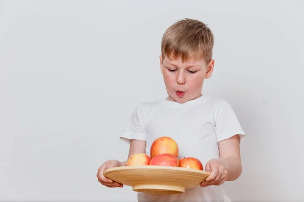 Překvapen Chlapec Drží Desku Jablky Bílém Pozadí — Stock fotografie