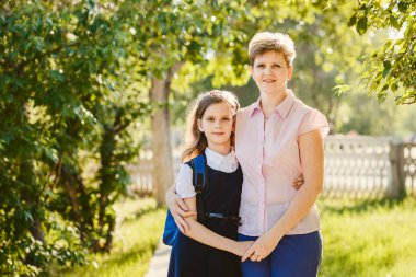 mutlu anne ve kızı kameraya açık havada seyir sırt çantası ile kız öğrenci