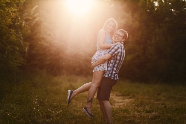 Adam bir kızı günbatımı ışığında yaz aylarında eller tutar