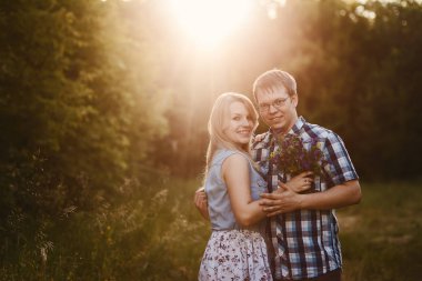 Genç mutlu evli çift sarılma ve açık havada kameraya bakıyor