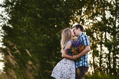 Genç adam ve kadın yaz aylarında gün batımında öp