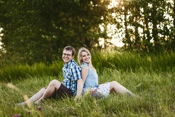 幸运的男孩和女孩坐在草地上 在夏天 — 图库照片