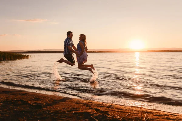 Парень Девушка Прыгают Море Закате Счастливая Семья — стоковое фото