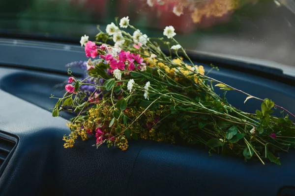 a bouquet of wild flowers lies in the car, Yellow Pink Bouquet of field flowers