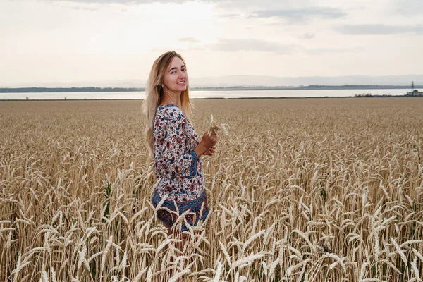 秋の小麦畑に立っている若い女性 — ストック写真