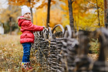 güzel kız sıcak bir ceket ve kot tribünlerde Sonbahar Park