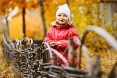 şirin kız açık havada Sonbaharın sıcak bir ceketi giyen beş yılın gülümseyen, sonbahar arka plan bulanık