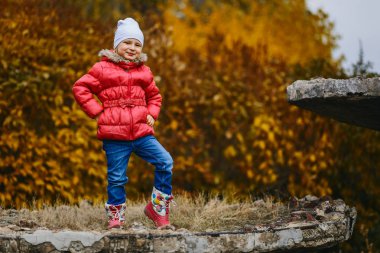 beş yaşındaki kız ceket ve kot sonbahar sarı yapraklar arka plan üzerinde gülümseyen şirin
