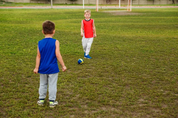制服プレーはサッカー緑の芝生の上で 人の幸せな男の子 — ストック写真